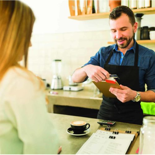 Barista swiping credit card in a coffee shop