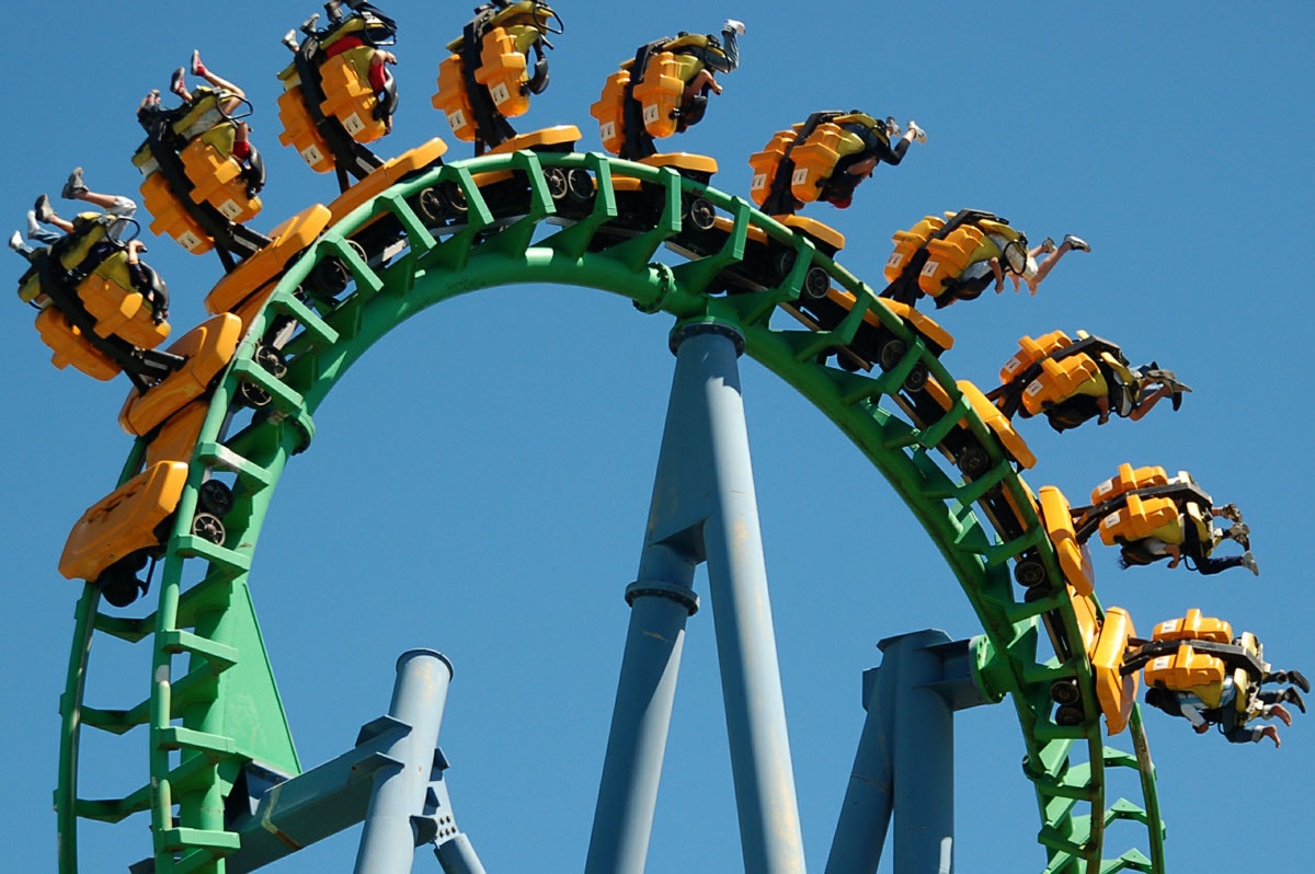 Riders flip upside down on a loop in a roller coaster track.