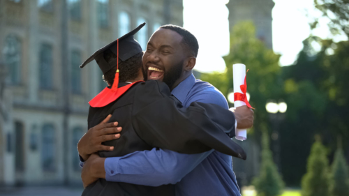 An excited dad hugs his graduate