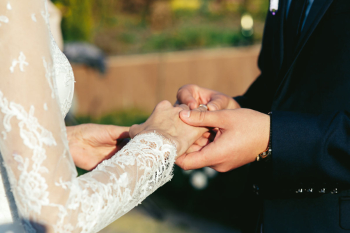 Bride and groom exchange rings during a wedding ceremony