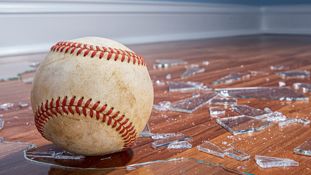 Broken glass and a baseball on the floor